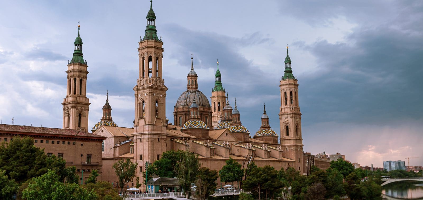 Las torres y las cúpulas de la basílica del Pilar de Zaragoza vistas desde la orilla del Ebro al atardecer